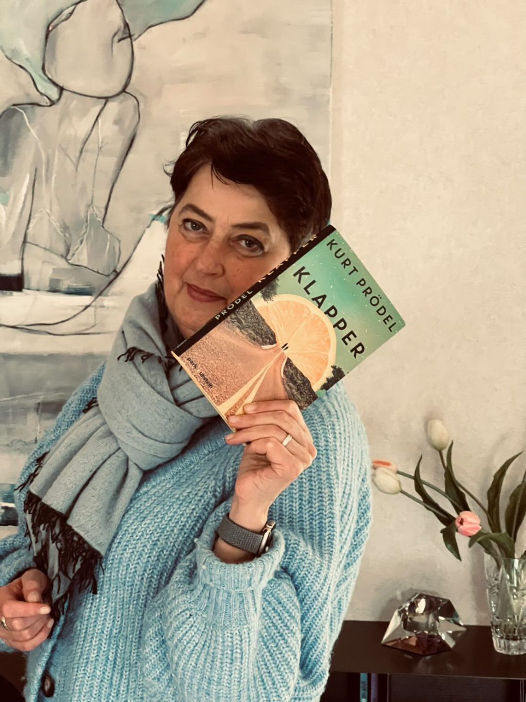 Frau Quint mit einem Buch in der Hand, platziert schr&auml;g neben ihrem Kopf
